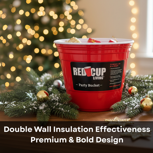 A red "Red Cup Living" party bucket on a festive Christmas setting with greenery and lights.